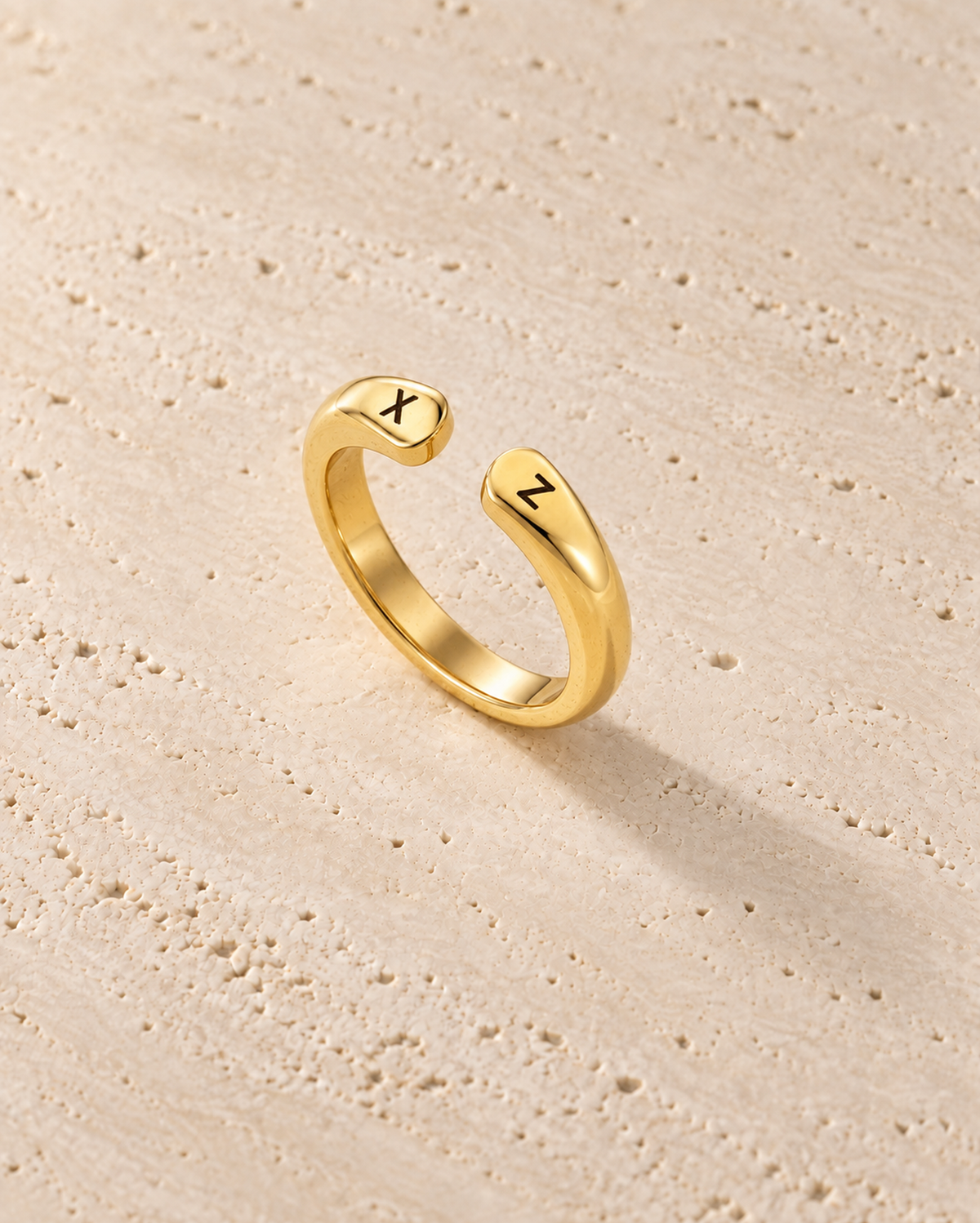 Double Initial Ring in goudkleur op warm travertin