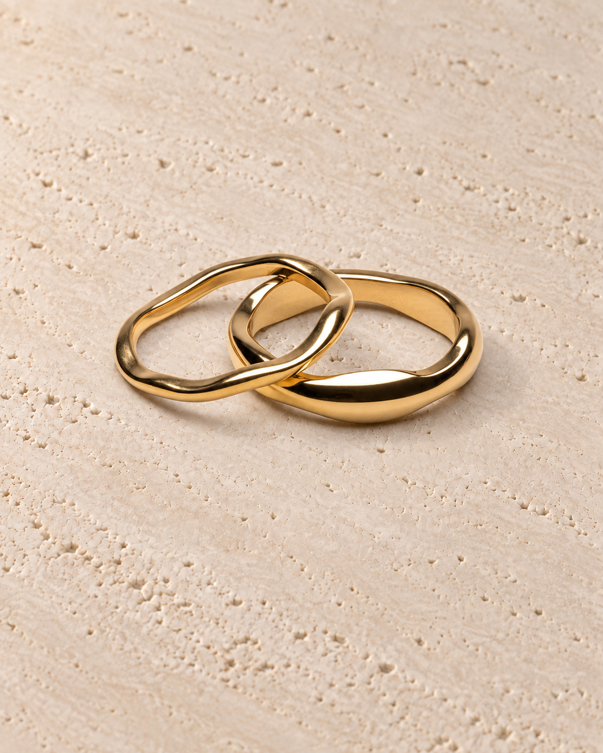 Insieme Ring Set in goudkleur op warm travertin