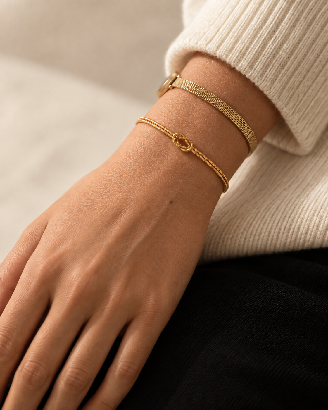 Goudkleurige Legame Knot Bracelet naast een horloge; horloge niet inbegrepen