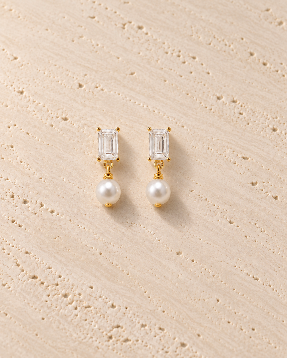 Luce Pearl Drop Earrings in goudkleur op warm travertin