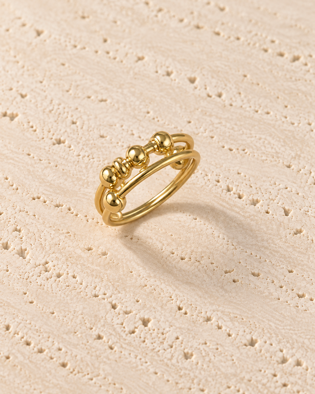 Mira Beaded Ring in goudkleur op warm travertin